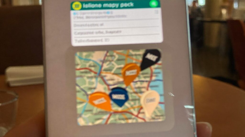 Smartfon z mapą i trzema pinezkami lokalizacji